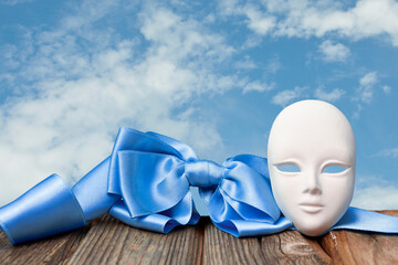 Mask with a blue bow on a background of the sky