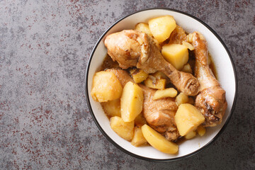 Indonesian cuisine chicken drumsticks stewed with potatoes in spicy sweet soy sauce close-up on the table. horizontal top view from above