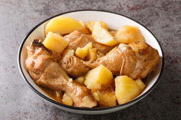 Indonesian cuisine chicken drumsticks stewed with potatoes in spicy sweet soy sauce close-up on the table. horizontal