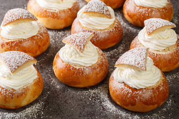 Scandinavian sweet buns stuffed with frangipane and whipped cream close-up on the table. Horizontal
