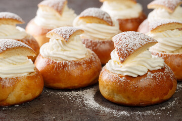 Semla Fastelavnsbolle Fastlagsbulle traditional scandinavian cream filled cardamom bun with almond paste closeup on the table. Horizontal