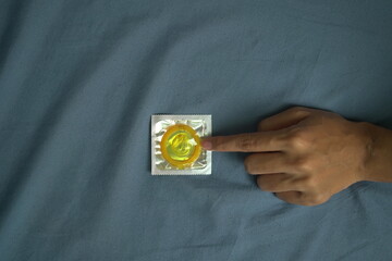 Close up female hands holding condoms ready to be used, preventing infection and contraception.