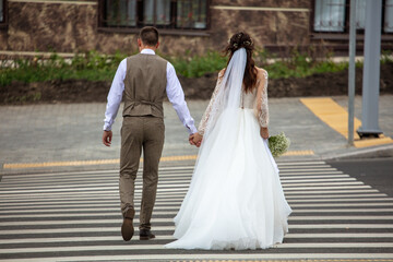 Obraz na płótnie Canvas Bride and groom at a pedestrian crossing.