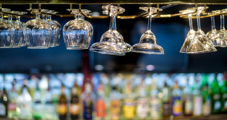 Fototapeta na wymiar Glasses hanging over a bar rack in the hotel restaurant.