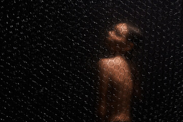 beautiful nude woman behind a polyethylene film