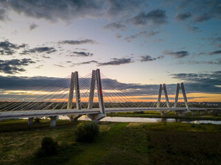 Most wiszący nad rzeką w czasie zachodu słońca - obrazy, fototapety, plakaty