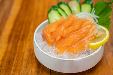 Salmon Sashimi, Japanese food, served with sliced cucumber and lemon over ice.