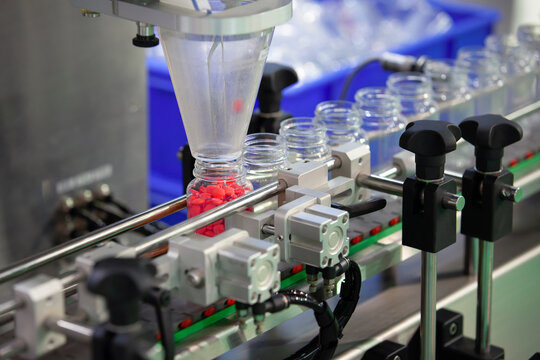 Medicine tablet or capsule counting machine in pharmaceutical industry. Industrial Machine for quality of medical product in line conveyor processing. Industrial and factory technology concept.