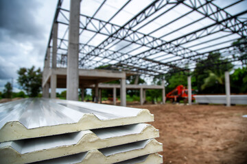 Metal roofing sheets are put together in the construction area of industrial buildings.