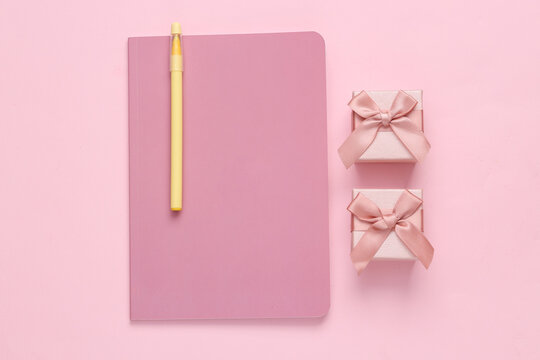 Girly diary and gift boxes on a pink background. Top view, flat lay