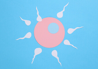 Ovulation, conception, reproductive concept. Spermatozoa with an egg cell on a blue background
