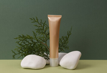 Aesthetic beauty or makeup still life. Foundation cream bottle with stone and herbal twig on two...
