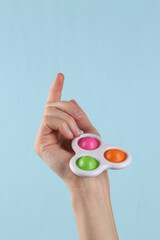 Simple dimple sensory antistress toys in female hand on a blue background.