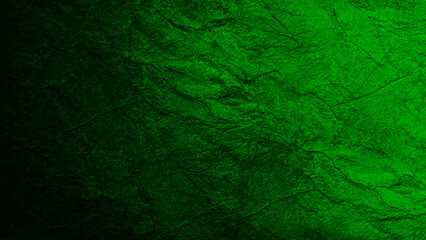 Black green stone background with cracks. Color gradient.Toned rough mountain surface. Close-up. Dark light. Green background with space for design. Halloween, creepy, spooky.