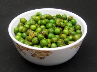 Indian snacks food spicy peas in a bowl on black background 