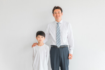 小学生の男の子とスーツ姿の男性（家庭教師・父親）
