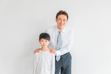 小学生の男の子とスーツ姿の男性（家庭教師・父親）
