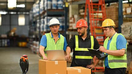 Storehouse employees workers in hardhats and and vests working together in warehouse. Logistics, and manufacture storehouse occupation concept