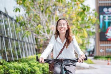Fototapeta na wymiar Confidence of Asian businesswoman go to office work at modern city street with bicycle, Eco friendly in the morning business female using bike concept.