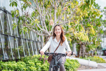 Fototapeta na wymiar Confidence of Asian businesswoman go to office work at modern city street with bicycle, Eco friendly in the morning business female using bike concept.