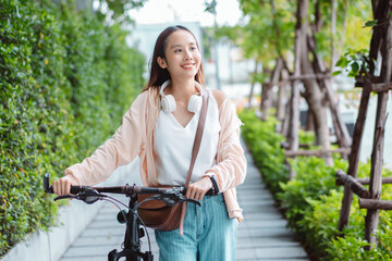 Fototapeta na wymiar Happy Asian young woman walk and ride bicycle in park, street city her smiling using bike of transportation, ECO friendly, People lifestyle concept..