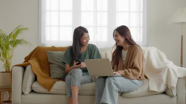 Two Asian Young Woman Happy Smiling And Using Computer Laptop On Couch In Living Room At Home