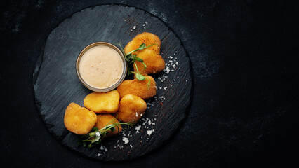 Cheese nuggets with sauce on black stone