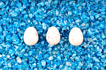 three eggs on blue decorative stones