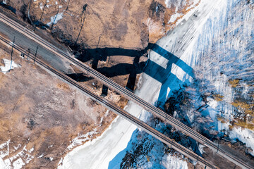 aerial photography railway bridge across the river, shadow from the bridge on the banks