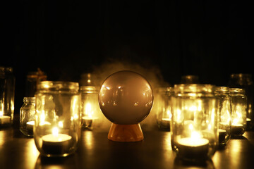 Black background with a ball and candles. Divination and prediction of fate.