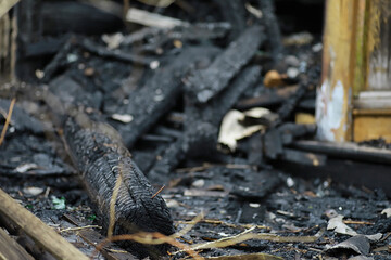 Wooden house after the fire. Coals on the logs. The ashes of the house from the fire. Burnt...