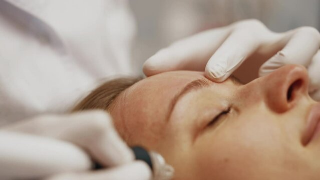 A professional cosmetologist performs hydropiling on a woman. Skin care.