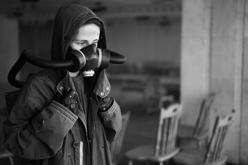 Fototapeta na wymiar Woman wearing big gas mask against contamination. Lockdown for virus pandemic. Post apocalypse specialist breathing in anti-virus and radiation gas mask. Doomsday clothing