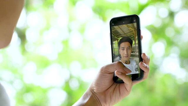 A Young Handsome Man Taking Multiple Selfie Below a Hut in the Nature