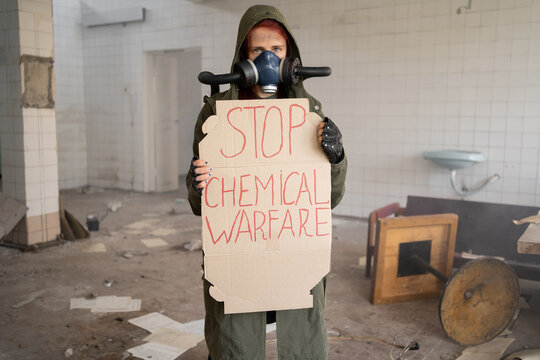 Photo of a military woman in a gas mask with banner says stop chemical warfare, apocalypse, nuclear weapons, atomic explosion of a station, chemical and nuclear weapons protection. Girl in a mask