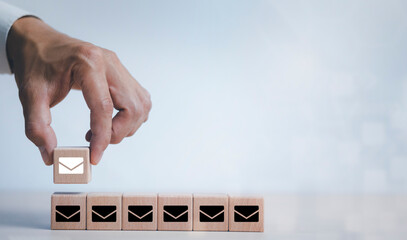 Hand touch wooden block cube and communication icons, letter icon, email icons, and newsletter...