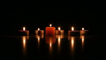  a candle and tea lights in a dark room 