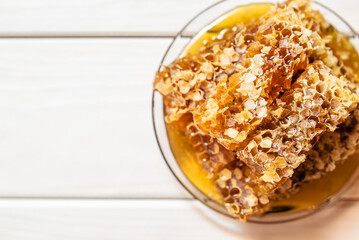 honey in honeycombs on a white wooden background
