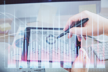 Double exposure of man's hands holding and using a phone and financial chart drawing. Market analysis concept.