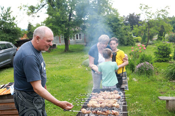 Man cooking pork kebabs on skewers