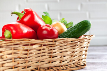Various vegetables in a wicker basket. Food. Tomatoes, onions, peppers, cucumbers.