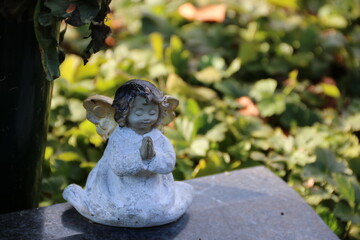 Kleiner Engel auf dem Friedhof auf einem Grabstein