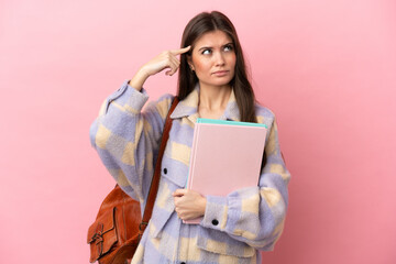 Young student woman isolated on pink background having doubts and thinking