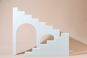 Geometric shapes stairs podiums and archs standing on a beige background