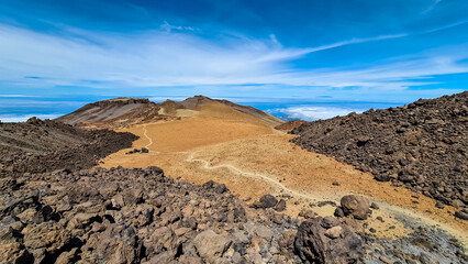 Panoramic view on crater of mountain Pico Viejo on hiking trail to volcano Pico del Teide, Mount Teide National Park, Tenerife, Canary Islands, Spain, Europe. Walking on barren volcanic desert terrain