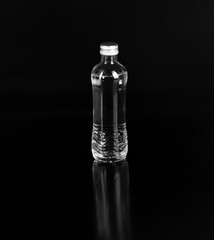 glass bottle with mineral water isolated on black background