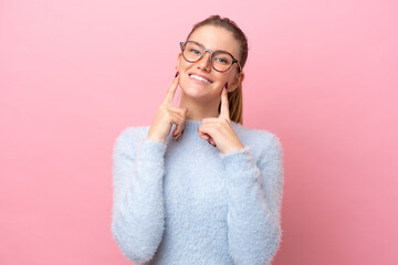 Young caucasian woman isolated on pink background smiling with a happy and pleasant expression