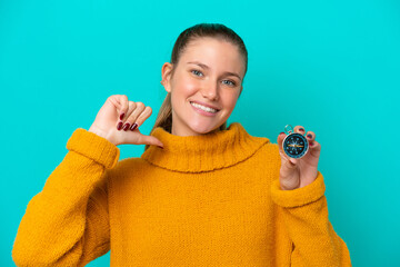 Young caucasian woman holding compass isolated on blue background proud and self-satisfied