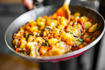 Woman cooking tasty vegetable stew in pan on kitchen