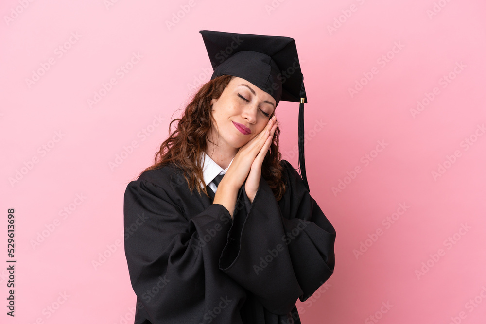 Canvas Prints Young university graduate woman isolated on pink background making sleep gesture in dorable expression